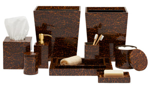 The Carmel High Gloss Faux Tortoise collection by Pigeon & Poodle offers brown marble-patterned bathroom accessories, including a tissue box, soap dispenser, toothbrush holder, tray, cotton jar, cup, and waste bins in a tortoise shell style.