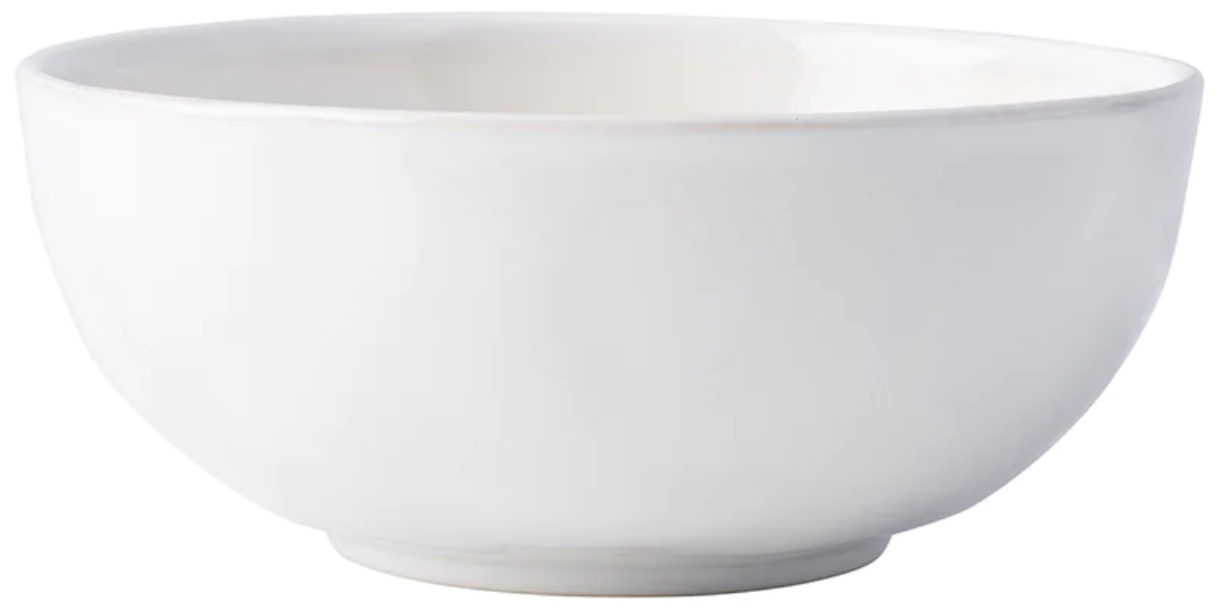 The Juliska Puro Whitewash Dinnerware Collection features a smooth, glossy ceramic bowl in crisp white—ideal for serving tapas or presenting teatime treats, seamlessly blending into any table setting with its versatile design.
