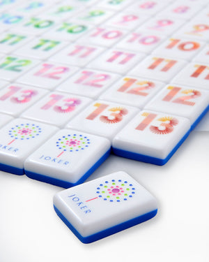 A close-up of Oh My Rummi Set tiles by Oh My Mahjong, showcasing vibrant numbered tiles and a Joker with multicolored dots—ideal for family game nights and fans of classic tile games.