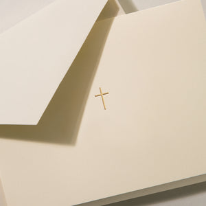 The Crane Gold Cross Note Card Set features cream-colored cotton paper cards with a small gold cross in the center, paired with matching envelopes.