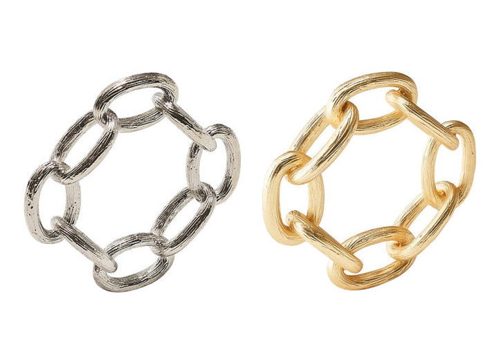 Two napkin rings from the Kim Seybert Chain Link Napkin Ring Collection—one in silver and one in gold—each crafted with six oval links, are displayed side by side on a white background, showcasing the elegant simplicity of chain-link design as a distinctive accent for your table setting.