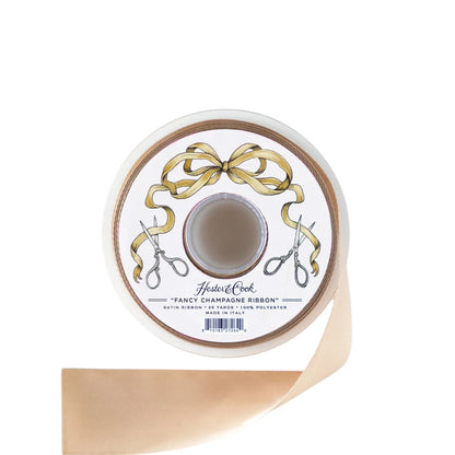 A spool of Hester & Cook’s Fancy Ribbon in a champagne satin finish, ideal for gift wrapping, with a label adorned with gold ribbon art and scissors.