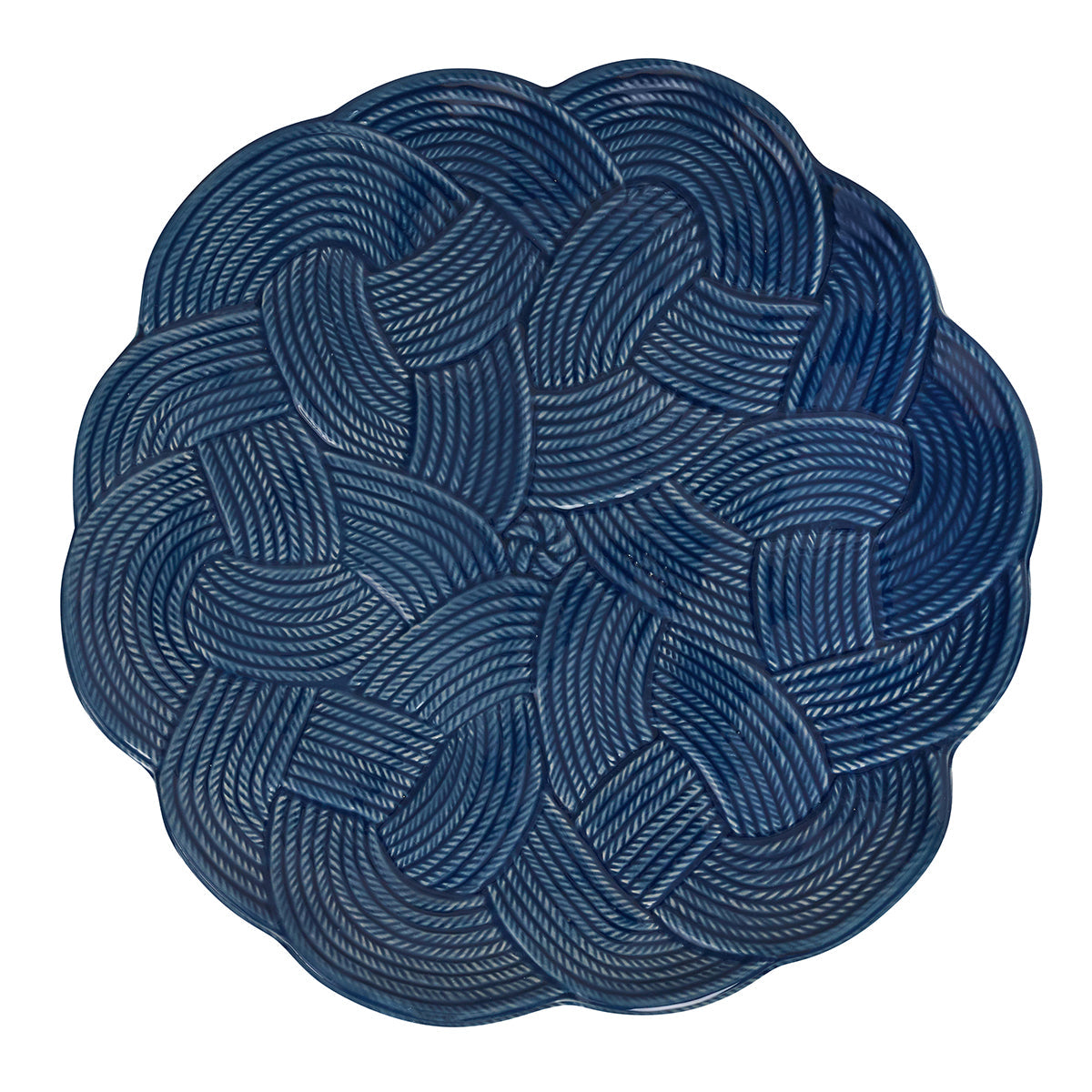 Presented on a white background, the Le Panier Mystic Knot Denim serving platter by Juliska features a round shape and a rich dark blue hue, adorned with an intricate braided pattern inspired by interwoven mystic knots.