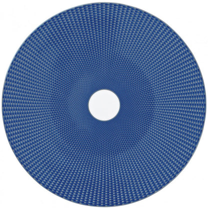 The Tresor Blue Dinnerware Collection by Raynaud features a round blue porcelain plate with a woven geometric pattern and a white center, offering subtle elegance.