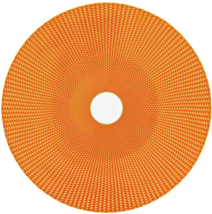 The Tresor Orange Dinnerware Collection by Raynaud features a circular orange disc with a grid-like textured pattern and a small white center, resembling hand-painted porcelain, seen from above.