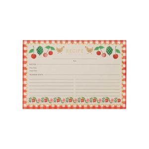 The Cherries Collection recipe card by Rifle Paper Co. features a red checkered border, cherry motifs, fruit and chicken illustrations, and labeled sections for notes, prep time, total time, and ingredients.