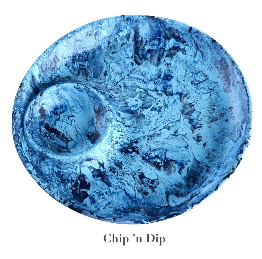 The Nashi Home Denim Resin Serveware Collection features a round blue marbled chip and dip serving plate with a built-in dip section—shatter resistant and perfect for stylish home decor.