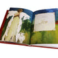 An open book from Anne Neilson’s "Christmas Angels: Devotions and Art of Hope and Joy for the Advent Season" shows an abstract painting of a woman with a white animal and a page titled "Week 3 Joy" in elegant script.