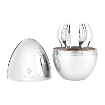 The Christofle MOOD Yummy Cocktail Silver Forks Set features a polished silver egg-shaped container with the lid removed, revealing six silver-plated cocktail forks standing upright inside. The mirror-polished steel case is branded with the Christofle logo.