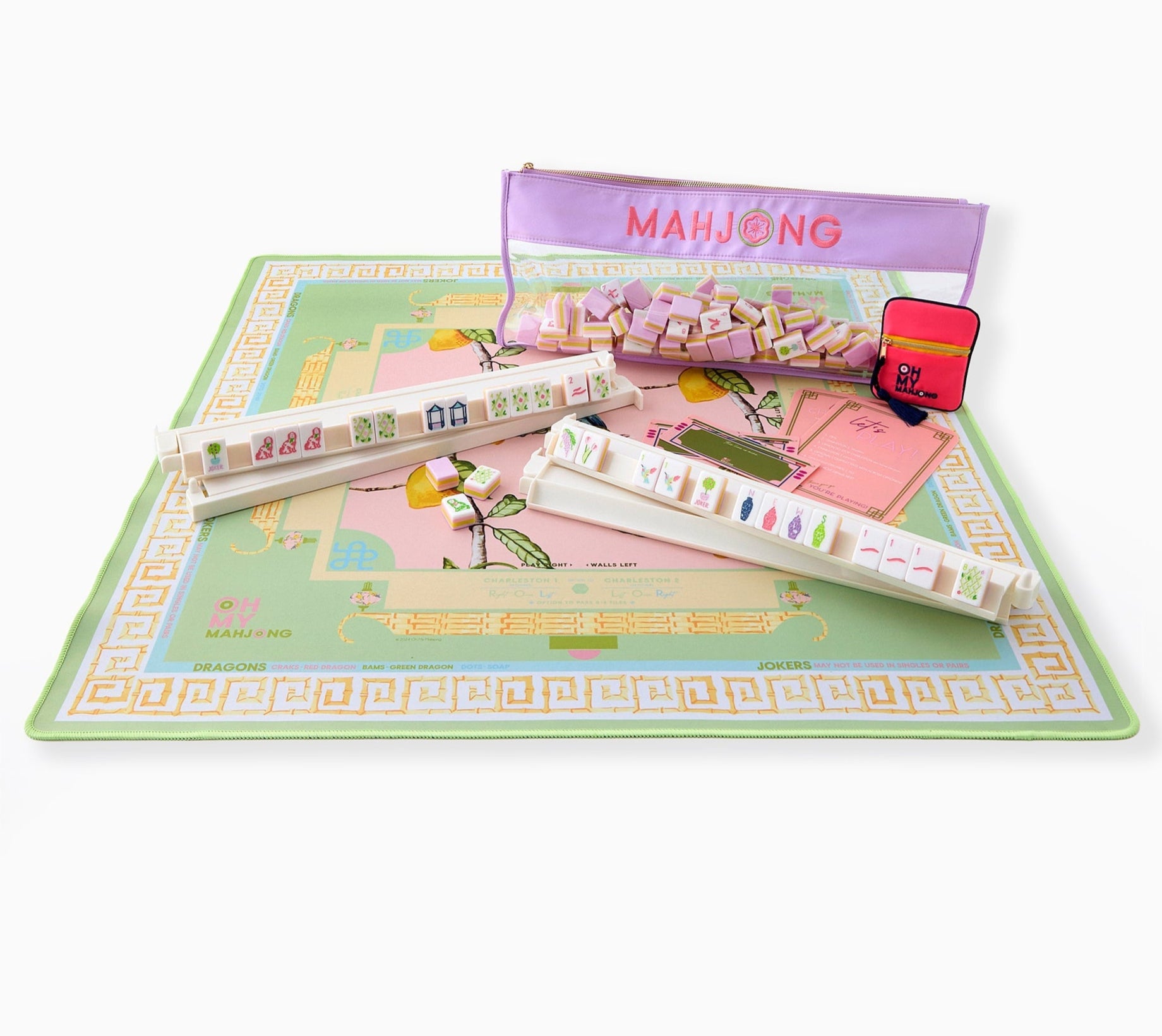 The Oh My Mahjong Mahjong Mat Collection features a pastel non-slip mat, four tile racks, tiles, a “MAHJONG” zippered case, and a red storage pouch, all arranged on a white background.