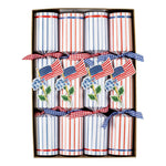 The Caspari Flags And Hydrangeas Collection features party crackers decorated with small American flags and blue hydrangeas, tied with checkered ribbons—perfect for adding patriotic flair to festive picnics or outdoor gatherings.