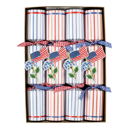 The Caspari Flags And Hydrangeas Collection features party crackers decorated with small American flags and blue hydrangeas, tied with checkered ribbons—perfect for adding patriotic flair to festive picnics or outdoor gatherings.