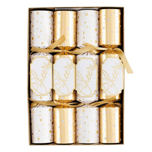 The Caspari Cheers To You Crackers box includes six festive crackers in gold and white—three with "Cheers" and three with polka dots—each tied with a gold ribbon and filled with hidden toy surprises.