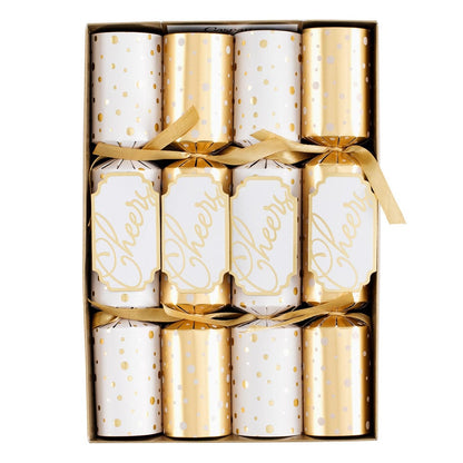 The Caspari Cheers To You Crackers box includes six festive crackers in gold and white—three with "Cheers" and three with polka dots—each tied with a gold ribbon and filled with hidden toy surprises.