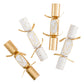 Celebrate with five Caspari Cheers To You Crackers in gold and white polka dots, each tied with gold ribbon and filled with festive toy trinkets.