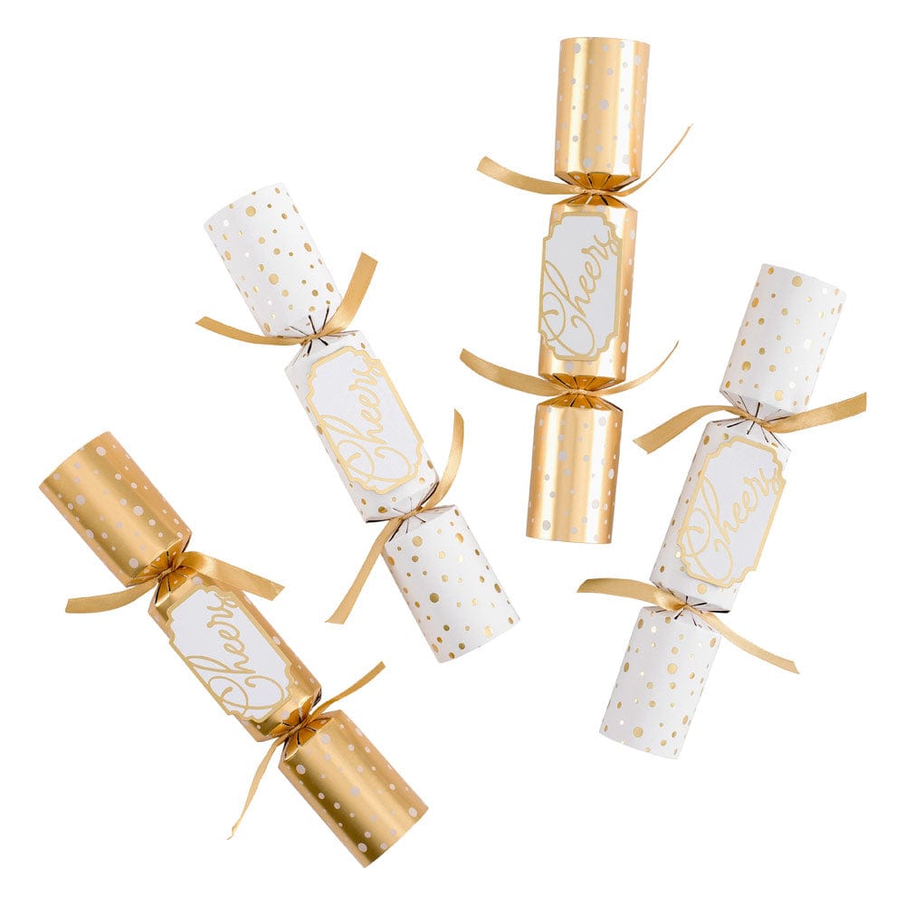 Celebrate with five Caspari Cheers To You Crackers in gold and white polka dots, each tied with gold ribbon and filled with festive toy trinkets.