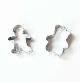 Two metal cookie cutters, inspired by classic Caspari designs and featured with White Christmas Crackers, are placed on a white background—one upright, one tilted.