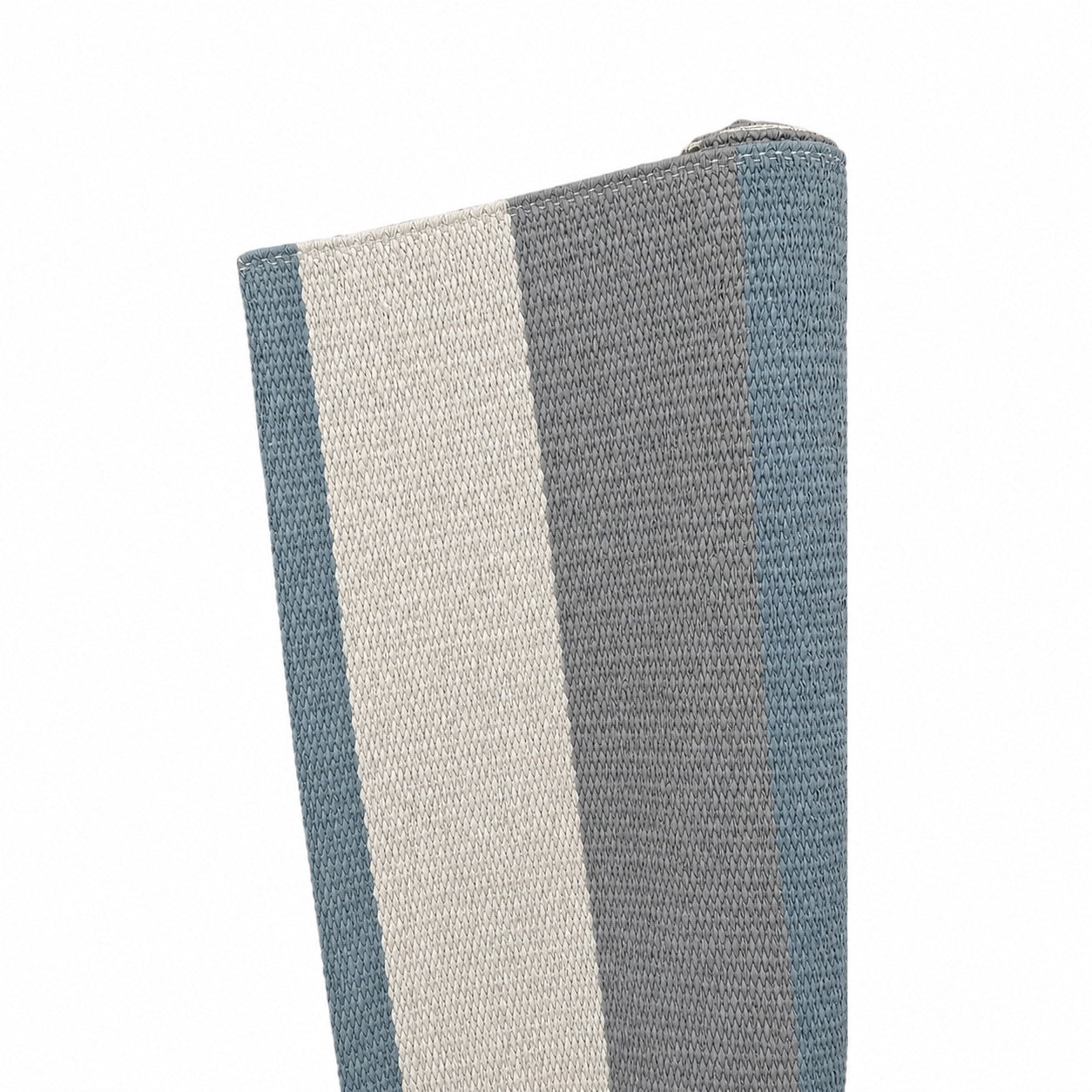 A close-up of the Magdalena York Lina Rug in Chalk, Dark Grey & James Blue, featuring folded vinyl fiber with vertical stripes against a white background.