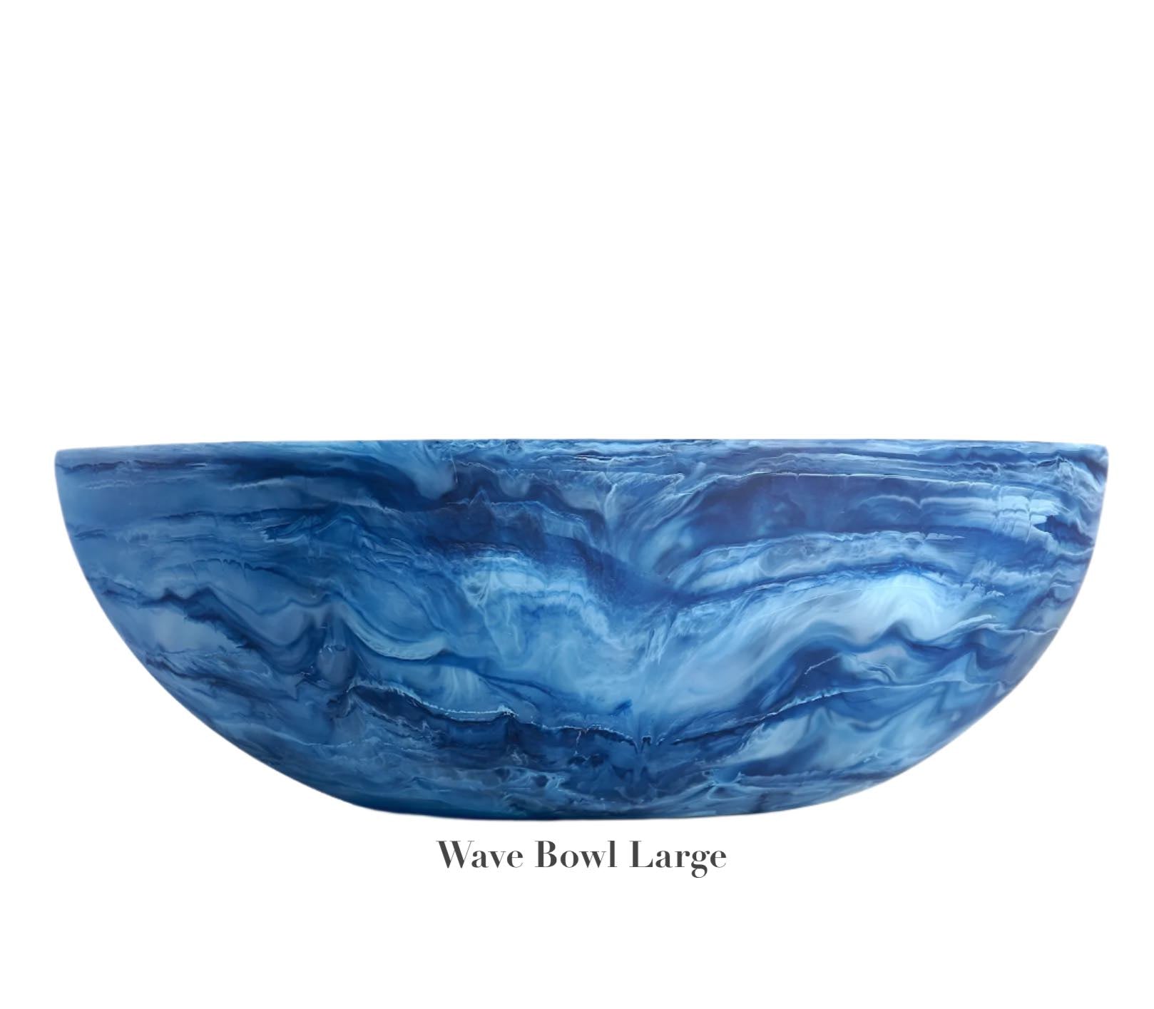 A large blue bowl with a marbled wave pattern from the Denim Resin Serveware Collection by Nashi Home rests on a white background. Crafted from shatter-resistant resin, it adds unique style to your home. Text: "Wave Bowl Large.