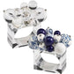 The Cloud Napkin Ring by Kim Seybert features two clear square Lucite rings—one with clear spheres, the other with blue, white, and patterned ceramic beads plus playful acrylic baubles.