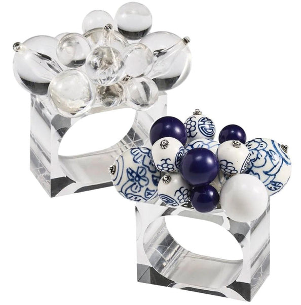 Two Kim Seybert Cloud Napkin Rings featuring a mix of blue and white acrylic baubles, with one ring showcasing floral designs on some beads.