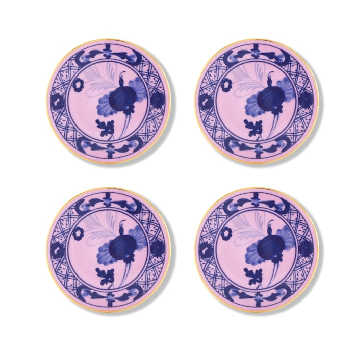 Four round porcelain plates from Ginori 1735's Oriente Italiano Azalea collection, featuring pink backgrounds, blue floral and geometric patterns, and yellow rims, are arranged two-by-two on a white surface. Perfect for elevating home decor.
