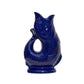 The Original Gluggle Jug’s Fish Gluggle Jug Collection features glossy blue ceramic jugs, handmade in England, with fish-shaped designs and open-mouth spouts—a classic British icon.