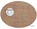 The Chilewich Oval Placemat in multicolored "Confetti" features a white plate, bowl, and brown chopsticks on the upper left—ideal for any dining occasion.