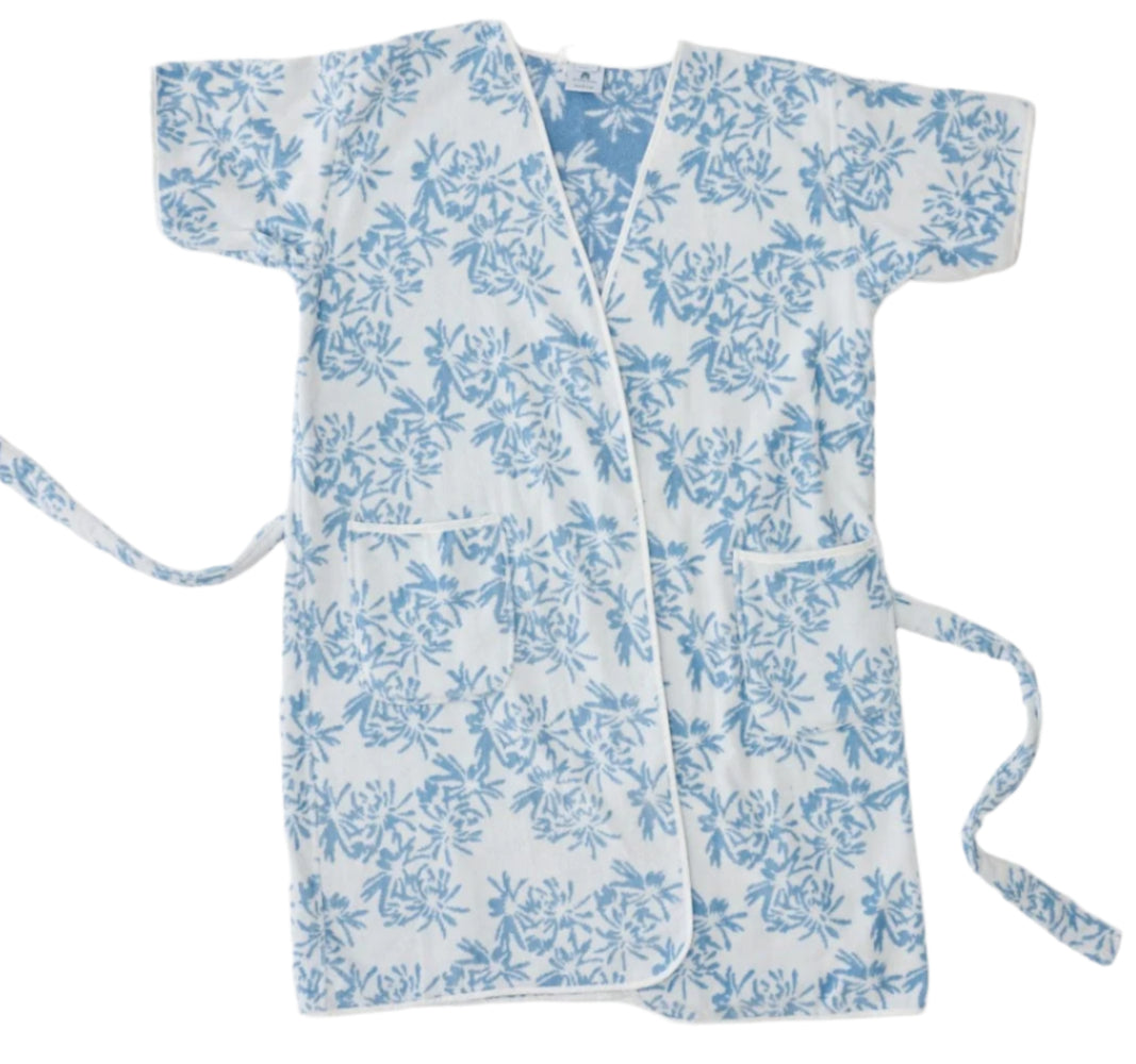 The Weezie Towels Meg Braff Short Patterned Robe is a luxurious white velour kimono-style robe with blue floral patterns, featuring short sleeves, a side tie closure, and handy pockets for ultimate comfort and style.
