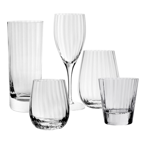 A collection of five William Yeoward Crystal Corinne Collection glassware items, including a tall glass, a stemmed wine glass, and three different sized tumblers, all featuring a vertical optic pattern.