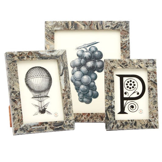 Three Pigeon & Poodle Corsica Frame Collection frames with decorative surfaces showcase a hot air balloon sketch, a grape drawing, and a stylized "P" with ornate details.