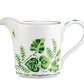 The Cobblers Cove Calypso Cream Pitcher by Royal Crown Derby features a handle and is adorned with vivid green leaf and fern patterns plus a slim gold rim—an elegant piece inspired by English fine bone china.