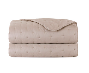 Folded taupe Triomphe Coverlet by Yves Delorme in luxury organic cotton with a tufted pattern.