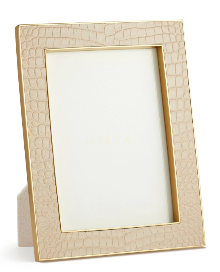 The Aerin Classic Croc Leather Frame Collection features a beige, Italian croc-embossed leather photo frame with a gold border, designed to stand upright and includes a blank insert.