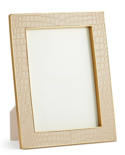 The Aerin Classic Croc Leather Frame Collection features a beige, Italian croc-embossed leather photo frame with a gold border, designed to stand upright and includes a blank insert.