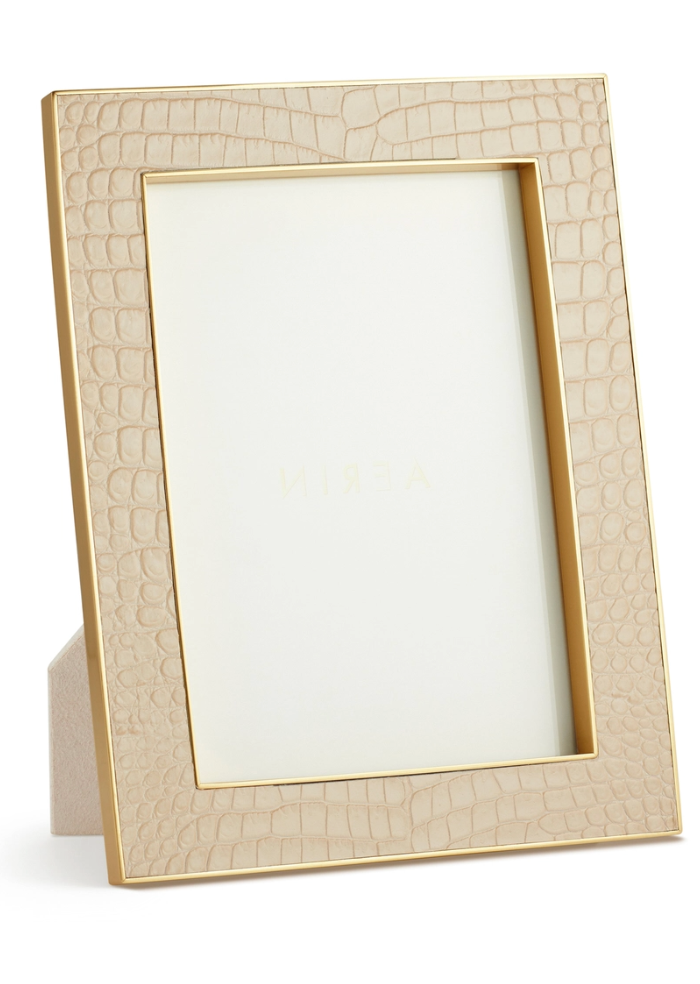 The Aerin Classic Croc Leather Frame Collection features a beige, Italian croc-embossed leather picture frame with gold trim, designed to stand upright and display your photos stylishly.