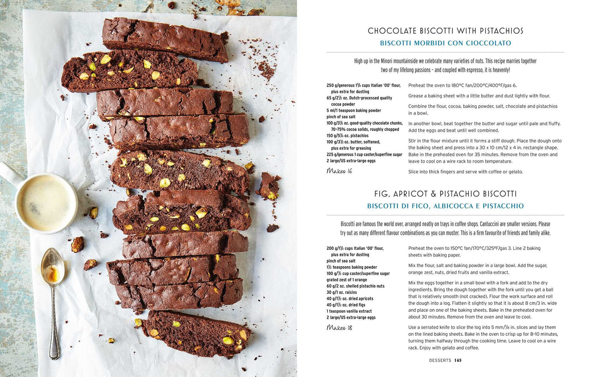 Sliced chocolate biscotti with pistachios rest on parchment paper beside a cup of milk, accompanied by recipe text for chocolate, fig, apricot, and pistachio biscotti from Cucina Di Amalfi By Ursula Ferrigno by Simon & Schuster—an inviting tribute to regional Italian cuisine and the rich heritage of Italian cooking.