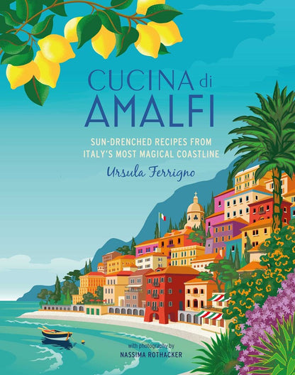 The cover of “Cucina Di Amalfi By Ursula Ferrigno” from Simon & Schuster features an illustration of colorful coastal buildings, a sparkling blue sea, lush green trees, and bright lemons, perfectly capturing the lively essence of regional Italian cooking. Both the title and Ursula Ferrigno’s name are prominently displayed.