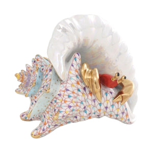 The Herend Reserve Collection Conch Shell with Curious Crab is a hand-painted porcelain figurine featuring a gold and red crab emerging from a colorful conch shell, perfect for adding charm to any collection.