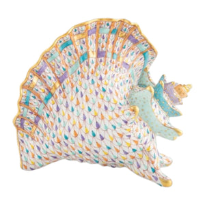 The Herend Reserve Collection Conch Shell with Curious Crab features a scalloped edge and pastel hand-painted geometric patterns in purple, blue, gold, and turquoise.