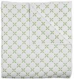 The Layla Bedding Collection by John Robshaw features a folded white quilt adorned with a repeating green geometric pattern inspired by Mughal gardens; the image displays both the front and a corner turned up to showcase the cotton voile backing.