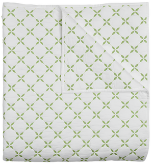 The Layla Leaf Coverlet by John Robshaw is a neatly folded white cotton voile quilt with a green geometric pattern inspired by Mughal gardens, shown with one corner turned back to reveal the same elegant design on the reverse.