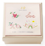 The Karen Adams XO Gift Enclosures set includes 8 hand-glittered cards in 2 styles with 8 envelopes, packaged in a cream-colored box with decorative art and "XO" and "love" accents.