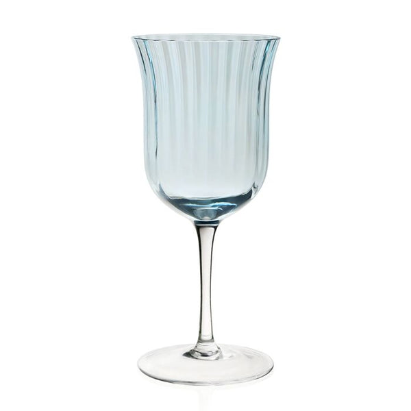 The William Yeoward Crystal Corinne Blue Collection goblet boasts a ribbed design and tall stem in a light blue hue, offering an elegant touch to any table set against a plain white backdrop.