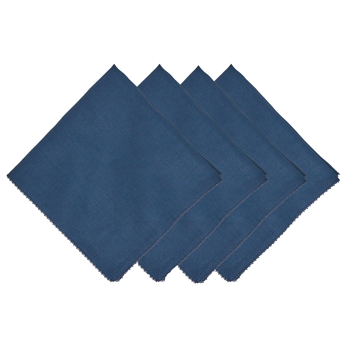 Four navy blue napkins from Juliska’s Berry Scallop Napkin & Tablecloth Collection are arranged in an overlapping row on a white background, evoking the look and feel of the brand’s woven linen tablecloths.