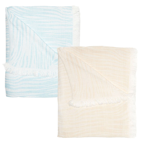 Two folded blankets from the John Robshaw Daasu Throw Collection feature fringed edging, one in light blue with a white striped pattern and the other in beige, made from soft stonewashed cotton.