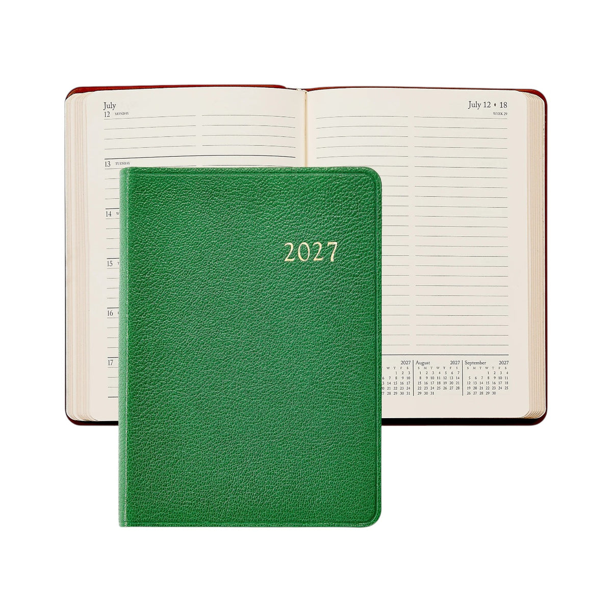 A Graphic Image 2027 Daily Journal in green is closed and placed on top of an open diary showing a weekly layout for July 12–18.