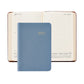 A blue Graphic Image 2027 Daily Journal is placed on top of an open diary, displaying dated pages for July 12 and July 13.