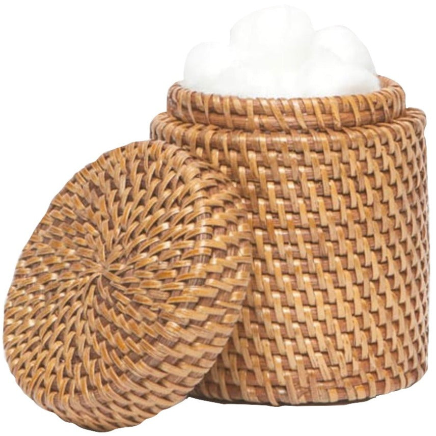 The Dalton Bath Collection by Pigeon & Poodle features a round woven basket with a detached lid, highlighting intricate craftsmanship and filled with white cotton balls.