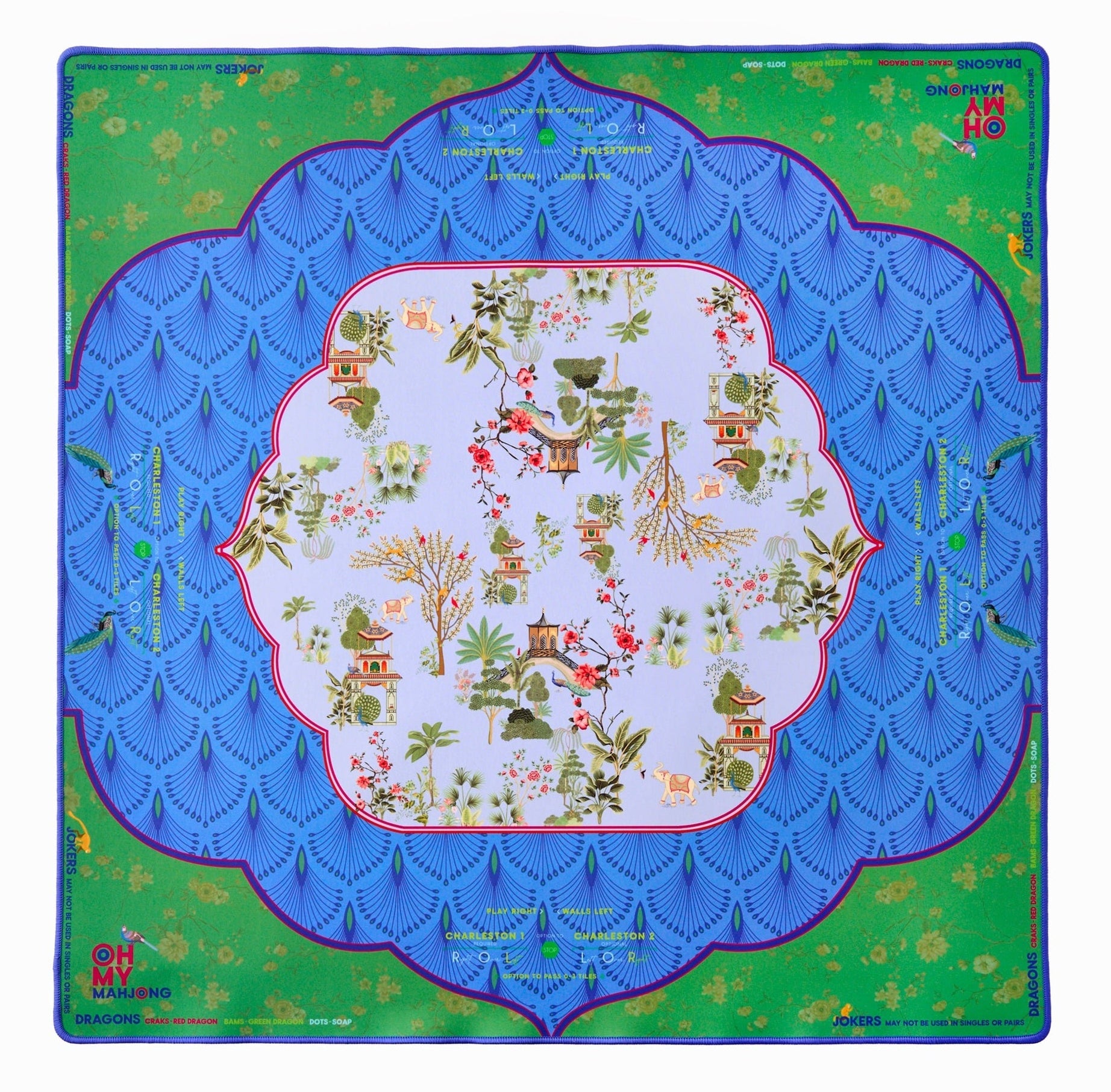 The Oh My Mahjong Mahjong Mat Collection features a square, non-slip mat with a blue scalloped pattern, green corners, and an Asian-inspired central design of trees, houses, and birds.